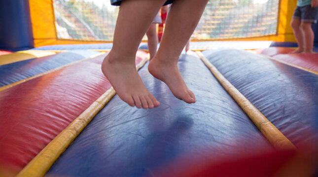 Children jumping in an inflatable bounce house with colorful flooring  