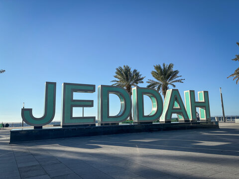 Large letters spelling Jeddah stand on the corniche beside two palm trees, Makkah, Jeddah, Saudi Arabia
