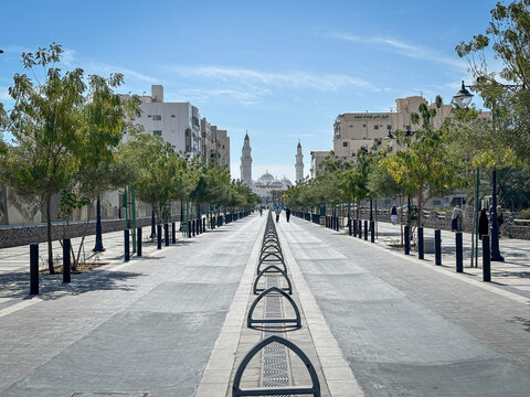A tree-lined avenue leads toward the minarets of the Quba Mosque, Al Madinah Province, Madinah, Saudi Arabia