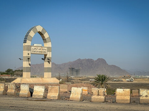 A stone arch marks the start of the Haram boundary against a mountain backdrop, Al Madinah Province, Madinah, Saudi Arabia