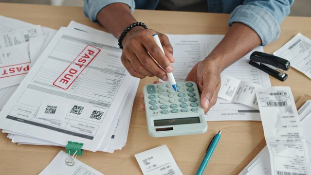 Person calculating bills with past due notice
