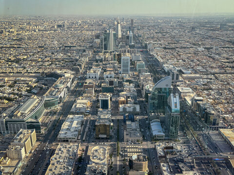 Warm sunlight rakes across the business towers of the skyline as seen from the Kingdom Centre, Riyadh, Riyadh, Saudi Arabia