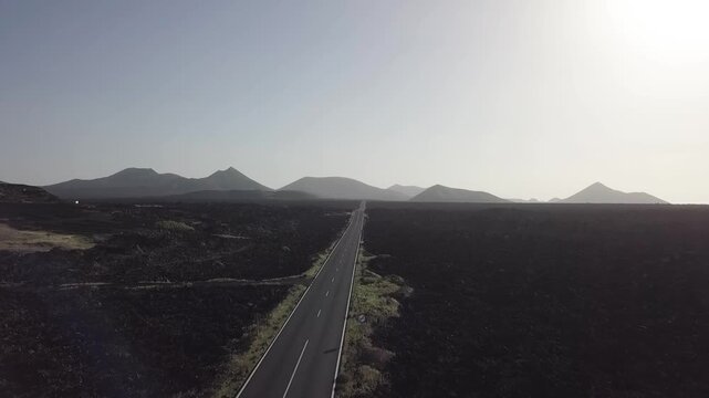 Straight road across a black lava landscape