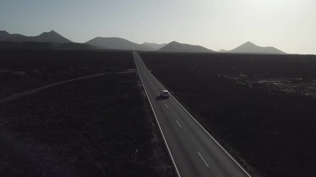 Vehicle crossing a volcanic plain by road