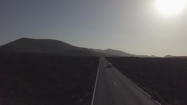 Car driving toward volcanic hills