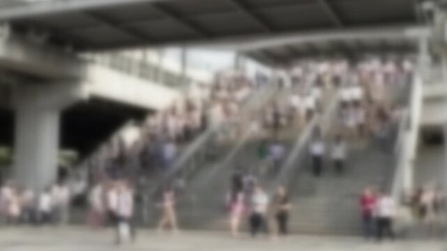 Blurred crowd of commuters climbing a wide station staircase in Bangkok
