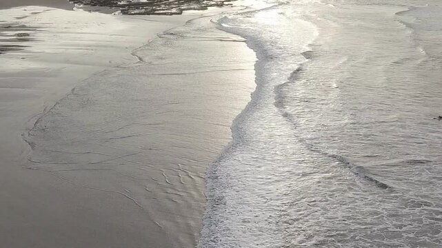 Sun reflection on surf and wet sand