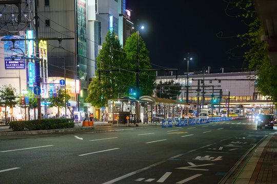 夜の駅前にある路面電車の停留場と都市交通