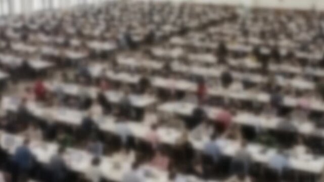 Blurred university study hall with every desk occupied by students
