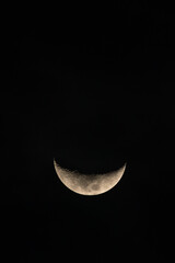 Crescent moon glows softly against deep, starless night sky © Carlos Cortez