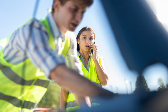 Woman calling for roadside assistance during car breakdown