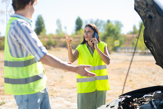 Woman arguing on phone after car breakdown on road
