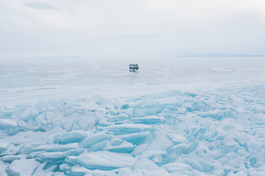 An SUV stands on a frozen lake