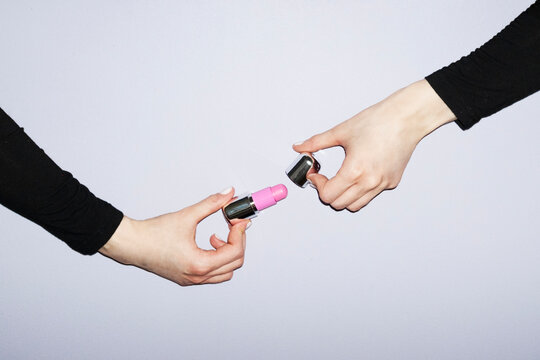 Hand holding pastel coloured minimal makeup skincare beauty products