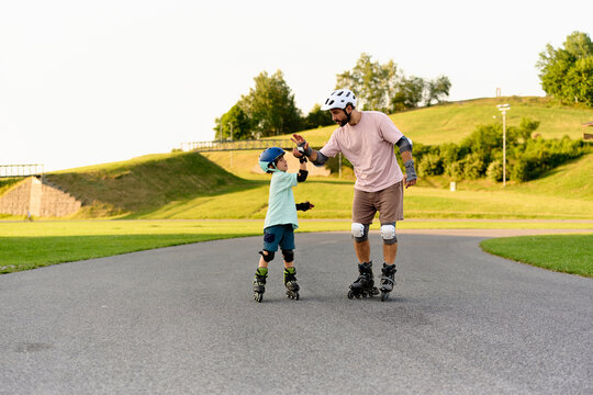 Father Helping His Son Learn Roller Skating