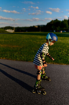 Little boy practicing roller skating at sunset