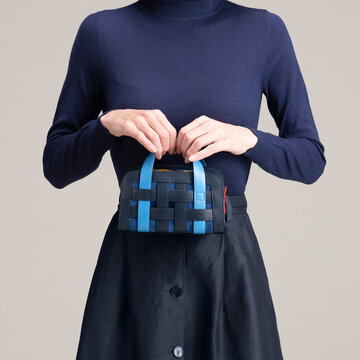 Hands Holding Blue Handbag With Navy Sweater