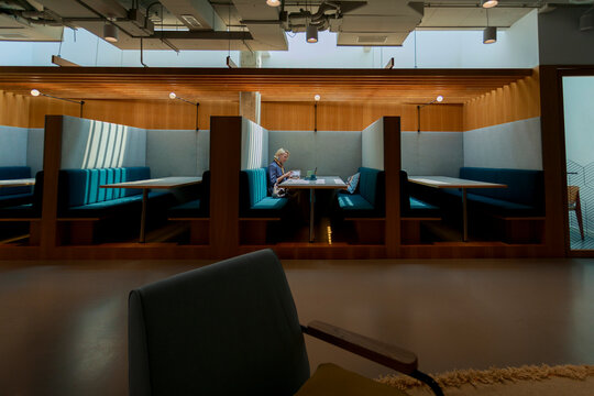 Person Sitting Alone in a Cafe Booth Working on a Laptop