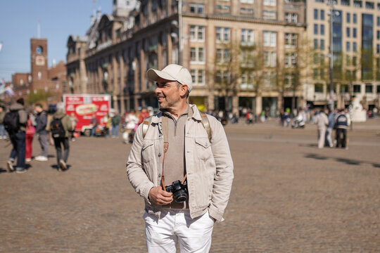 Confident Male Traveler Smiling at Amsterdam Plaza