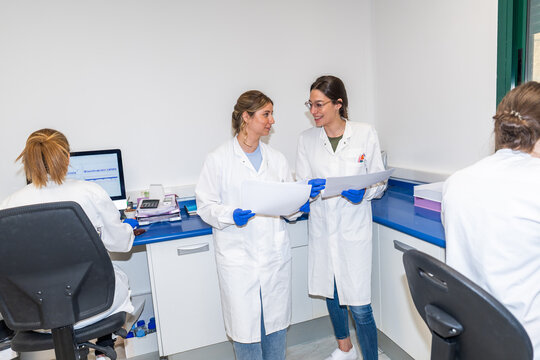 Women Scientists Holding Documents in A Laboratory.