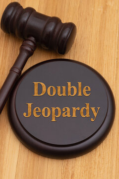 Double Jeopardy text with a judge gavel and block on wood desk