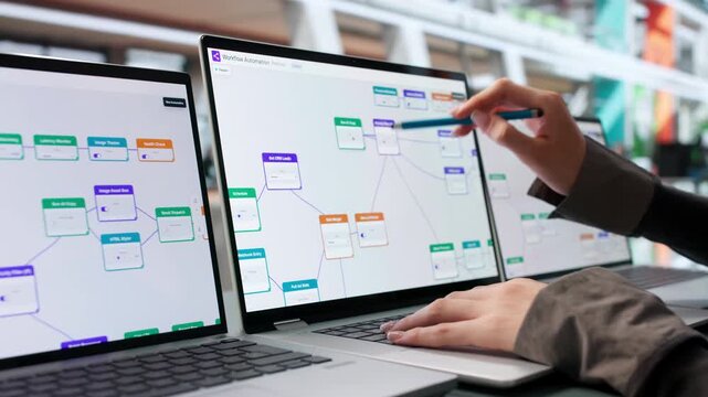 Business Analyst Reviews Workflow Automation Tasks Using Laptop