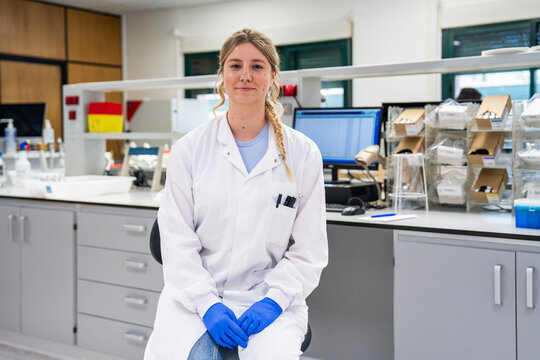 Scientist in Laboratory Wearing a Lab Coat and Gloves
