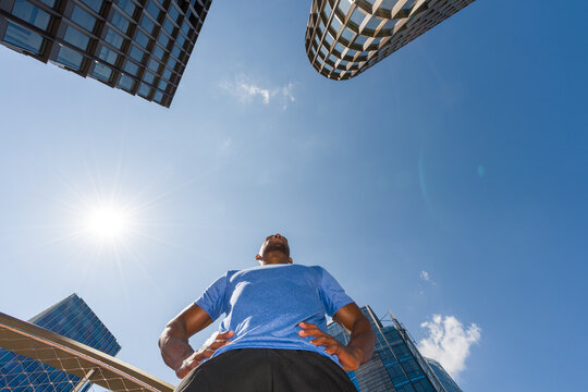 Sportsman Near Tall Buildings on Sunny Day
