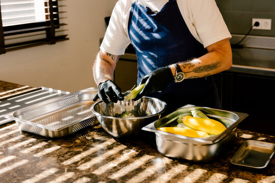 Chef peeling fresh organic pumpkins in luxury restaurant kitchen.