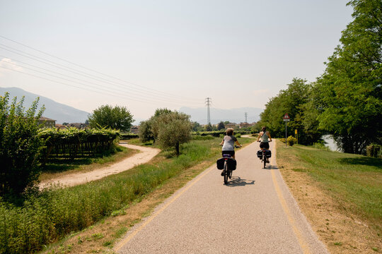 Mother and adult daughter cycling through northern Italy countryside