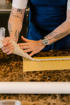 Chef filling pasta with pastry bag in luxury restaurant
