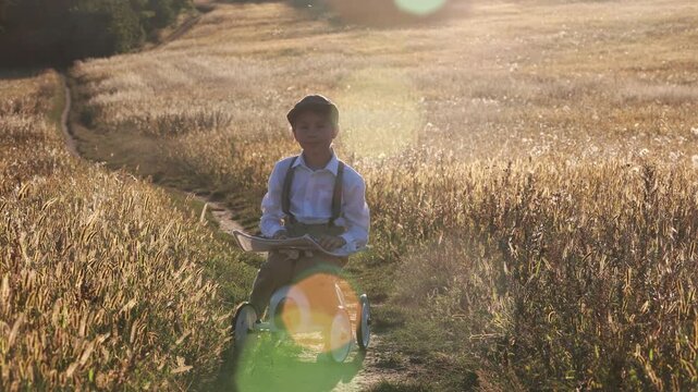Sweet preteen child, boy, playing in a field on sunset with kite and old vingate car, walking with grandmother in the countryside
