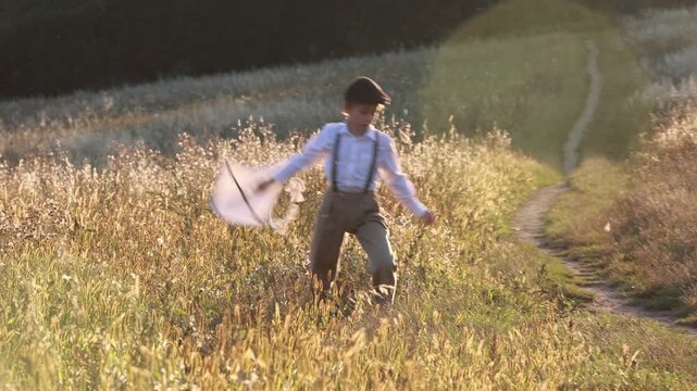 Sweet preteen child, boy, playing in a field on sunset with kite and old vingate car, walking with grandmother in the countryside