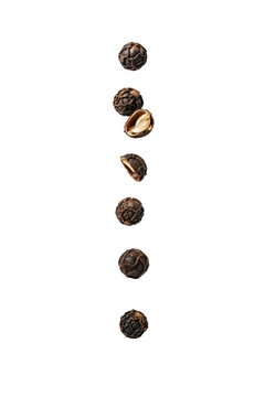 Black peppercorns falling on transparent.