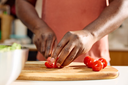 Person is chopping cherry tomatoes