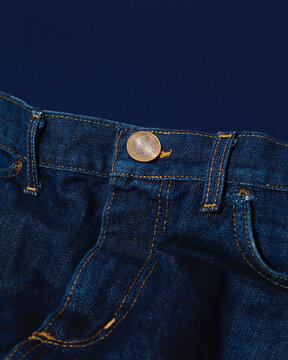 Close-up of blue jeans with golden euro coin as button in the front