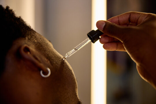 Anonymous applies lotion to his face