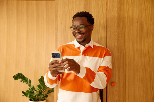 Portrait of a man smiles at his phone