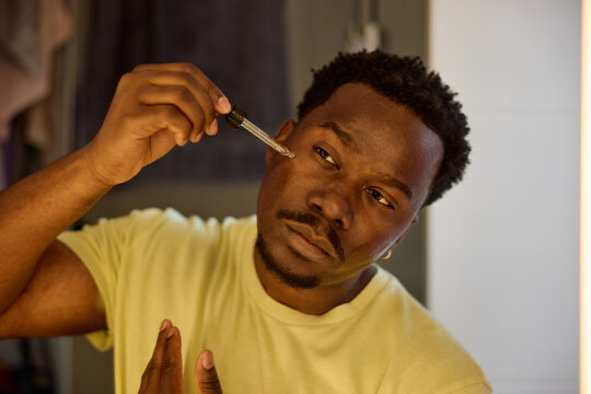 Man applies lotion to his face