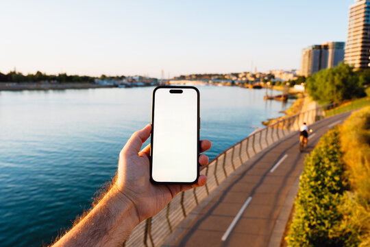 White Screen Phone at a Riverside Promenade