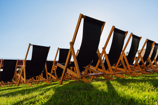 Empty Black Deck Chairs on a Sunny Lawn