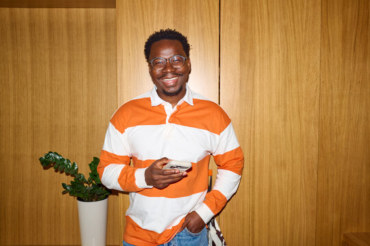 Man smiles at the camera while standing indoors