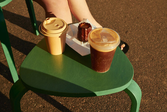 Small table with disposable coffee cups and canele