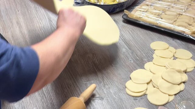 Woman Rolling Out Dough for Dumplings on Table