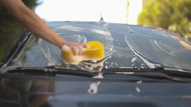 Washing a car with a soft sponge and rich foam close-up