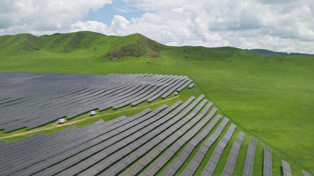 High-Angle Aerial View of Solar PV Panel Array on Zoige Grassland Mountains, Aba, Sichuan: Renewable Clean Energy, Agrivoltaics, Green Hills, Blue Sky and Cloud Background