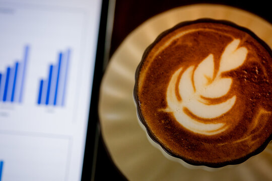 Business Professional Analyzing Data on Tablet with Coffee at Work