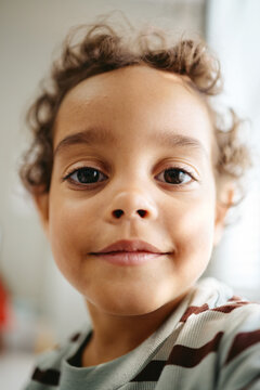 Vertical portrait of African American child smiling during pediatrician visit. Visual useful for pediatric healthcare marketing, childcare clinic promotion