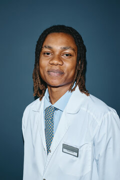 Vertical portrait of young adult African American man pediatrician looking at camera. Healthcare professional image suitable for medical clinic marketing and staff directory