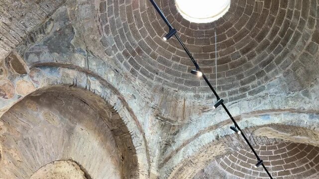 Architectural details of the Church of Saint Nicholas in Turkey, showcasing intricate stone arches and circular skylight illuminating the interior space